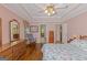 Main bedroom with sitting area, ceiling fan, wood floors, and view into the ensuite bathroom at 30 Joe Lee Dr, Sharpsburg, GA 30277