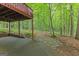 Covered patio with concrete flooring, brick trim, and a view of a lush, wooded backyard at 30 Joe Lee Dr, Sharpsburg, GA 30277