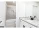 Modern bathroom featuring granite countertop vanity and tiled tub with a recessed shelf at 3402 Arabian Farm Ln, Dacula, GA 30019