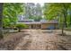 View of the house with yellow siding surrounded by trees and a wooded backyard at 2201 Valley Creek Cir, Snellville, GA 30078