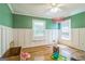 Empty green bedroom with two windows, hardwood floors, and white chair rail at 2201 Valley Creek Cir, Snellville, GA 30078