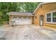 Exterior shot of garage and side entryway with yellow siding and driveway at 2201 Valley Creek Cir, Snellville, GA 30078
