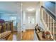 Bright foyer features hardwood floors, decorative pillars, and a staircase with carpeted steps at 2201 Valley Creek Cir, Snellville, GA 30078