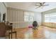 A paneled room with hardwood flooring, two windows, and a ceiling fan at 2201 Valley Creek Cir, Snellville, GA 30078