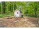 Exterior shot of wooden shed with white doors and fence in wooded backyard at 2201 Valley Creek Cir, Snellville, GA 30078