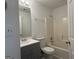 Bathroom featuring a vanity with a gray cabinet, a mirror, a toilet, and a shower with tub at 7090 E Village Ct, Riverdale, GA 30296