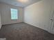 Bright bedroom featuring neutral carpet and natural light from a window at 7090 E Village Ct, Riverdale, GA 30296