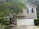 Close-up of a charming two-story home with a two-car garage and well-maintained landscaping at 7090 E Village Ct, Riverdale, GA 30296