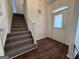 Bright foyer featuring hardwood floors, a staircase, and decorative front door at 7090 E Village Ct, Riverdale, GA 30296