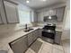 Modern kitchen with stainless steel appliances, granite countertops, and gray cabinetry at 7090 E Village Ct, Riverdale, GA 30296