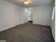 Spacious living room with neutral carpet and multiple entryways, offering a versatile layout at 7090 E Village Ct, Riverdale, GA 30296