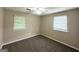 Cozy bedroom featuring neutral paint, modern ceiling fan, and windows with verdant views at 6309 Wellington Way, Austell, GA 30106