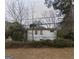 Quaint single-story home with peeling paint, surrounded by overgrown landscaping, offering a glimpse of potential at 2010 Mcafee Pl, Decatur, GA 30032