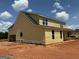 New construction featuring a yellow exterior, black roof, and attached garage at 242 Old Jackson Rd, Mcdonough, GA 30252
