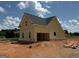 New construction featuring a yellow exterior, black roof, and attached garage at 242 Old Jackson Rd, Mcdonough, GA 30252