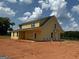 New construction featuring a yellow exterior, black roof, and a covered porch at 242 Old Jackson Rd, Mcdonough, GA 30252