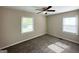 Cozy bedroom featuring two windows for natural light, neutral carpet, and a ceiling fan at 2851 Mitchell Dr, Decatur, GA 30032