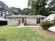 Exterior view of single-story home featuring a red front door and a covered parking area on the side at 2851 Mitchell Dr, Decatur, GA 30032