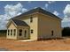 Exterior back view of yellow two-story home with dark roof and patio at 252 Old Jackson Rd, Mcdonough, GA 30252