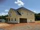 Exterior of the yellow two-story home showing garage and covered porch at 252 Old Jackson Rd, Mcdonough, GA 30252