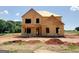 This is a two-story home in the framing stage of construction with a plywood exterior on a dirt lot at 252 Old Jackson Rd, Mcdonough, GA 30252