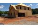 This is a two-story home in the framing stage of construction with a plywood exterior on a dirt lot at 252 Old Jackson Rd, Mcdonough, GA 30252