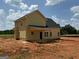 New construction features yellow siding, black roof, white trim, and a charming covered porch at 1916 King Mill Rd, Mcdonough, GA 30252
