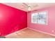 Vibrant bedroom with bright pink walls, a window, and neutral carpet at 421 Old Ivy Path, Mcdonough, GA 30253
