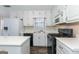 Bright kitchen featuring white cabinetry, stainless steel appliances, and wood-look flooring at 421 Old Ivy Path, Mcdonough, GA 30253