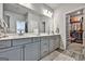 Bright bathroom featuring a double vanity with gray cabinets and a walk in closet at 4760 Highside Way, Smyrna, GA 30082