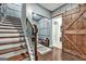 Stylish hallway featuring hardwood floors, a staircase, and barn door, leading to different home areas at 4760 Highside Way, Smyrna, GA 30082