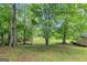 Lush backyard with mature trees and a glimpse of a shed at 4820 Yeager Rd, Douglasville, GA 30135