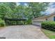 Long driveway leads to a garage and covered parking area surrounded by lush greenery at 4820 Yeager Rd, Douglasville, GA 30135