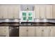 Close up of stainless steel sink, dishwasher, and cabinets beneath a window in this updated kitchen at 4820 Yeager Rd, Douglasville, GA 30135