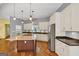 Bright kitchen with hardwood floors, stainless steel appliances, recessed lighting, and a spacious center island with cooktop at 4820 Yeager Rd, Douglasville, GA 30135