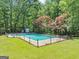 Beautiful in-ground pool surrounded by lush greenery and a secure fence at 4820 Yeager Rd, Douglasville, GA 30135