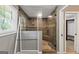 Beautiful tiled shower with glass surround, shower head, seating, and towel racks at 4820 Yeager Rd, Douglasville, GA 30135