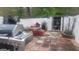 Back patio area with brick pavers, storage shed, grill, and white fencing for privacy at 6880 Mountain Cir, Riverdale, GA 30274