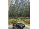 View of the back yard with a car parked on a concrete slab and the treeline visible behind it at 175 Forest Lake Dr, Fayetteville, GA 30215