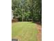 Lush backyard featuring a well-kept lawn and surrounded by beautiful, mature trees at 175 Forest Lake Dr, Fayetteville, GA 30215
