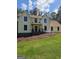 Charming two-story home with front porch, manicured front yard and lush trees under a partly cloudy sky at 175 Forest Lake Dr, Fayetteville, GA 30215
