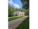 Charming two-story home with long driveway and well-manicured front yard, surrounded by lush trees at 175 Forest Lake Dr, Fayetteville, GA 30215