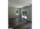 Bright living room with wood floors, large window, and sliding glass doors to the backyard at 175 Forest Lake Dr, Fayetteville, GA 30215
