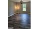 Living room featuring a large window, modern light fixture, and wood-look flooring at 175 Forest Lake Dr, Fayetteville, GA 30215