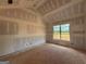Unfinished bedroom showcasing vaulted ceilings and natural light from a large window at 1926 King Mill Rd, Mcdonough, GA 30252
