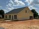 New construction displaying a yellow exterior siding, black roof and concrete patio at 1926 King Mill Rd, Mcdonough, GA 30252