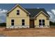 New construction home with yellow siding and a black roof, exuding modern charm at 1926 King Mill Rd, Mcdonough, GA 30252