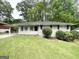 Charming home boasts a well-manicured lawn and inviting curb appeal with a side carport at 2651 Lois Se Ln, Atlanta, GA 30315