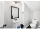 Cozy half bath with a pedestal sink, toilet, and decorative mirror at 1016 Buckeye Ln, Villa Rica, GA 30180