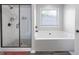 Bright bathroom showcases a glass enclosed shower and soaking tub under window at 1016 Buckeye Ln, Villa Rica, GA 30180